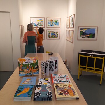 Deux clientes visitent l'exposition d'illustrations originales de Laurent Moreau